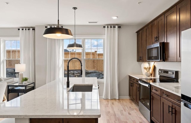 2 Codman Way Unit 301, Westborough, MA 01581 - kitchen featuring stainless steel appliances, light wood-type flooring, dark brown cabinetry, and healthy amount of natural light