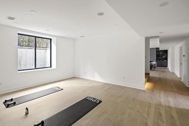 interior space with light wood finished floors, visible vents, and baseboards