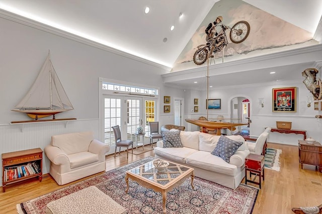 living room with french doors, ornamental molding, light hardwood / wood-style floors, and high vaulted ceiling