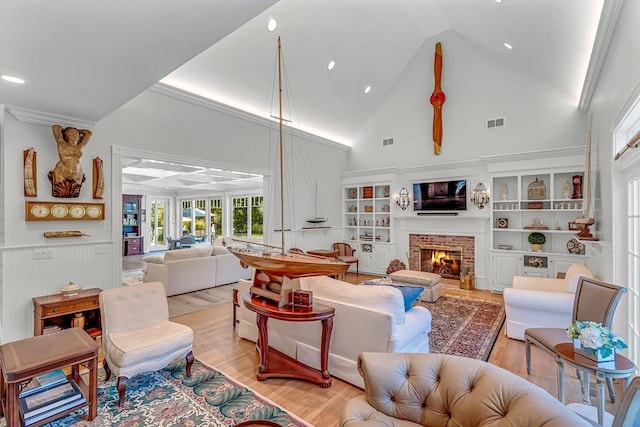 living room featuring a fireplace, high vaulted ceiling, and light wood-type flooring