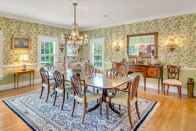 dining room with crown molding, a healthy amount of sunlight, a chandelier, and light hardwood / wood-style floors