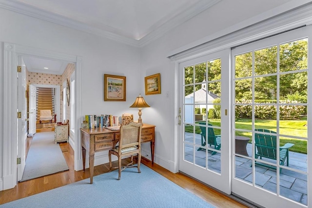 doorway featuring ornamental molding and light hardwood / wood-style floors