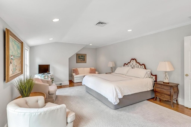 bedroom featuring crown molding, vaulted ceiling, and hardwood / wood-style floors