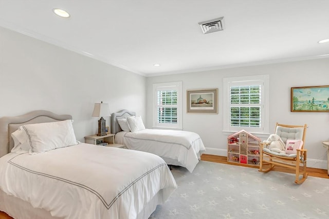 bedroom featuring multiple windows, ornamental molding, and light hardwood / wood-style flooring