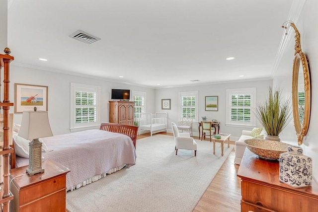 bedroom featuring multiple windows, ornamental molding, and light hardwood / wood-style flooring