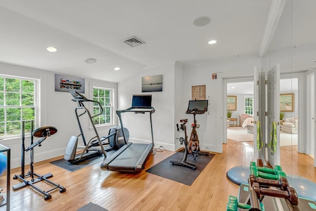 exercise room with hardwood / wood-style flooring and vaulted ceiling