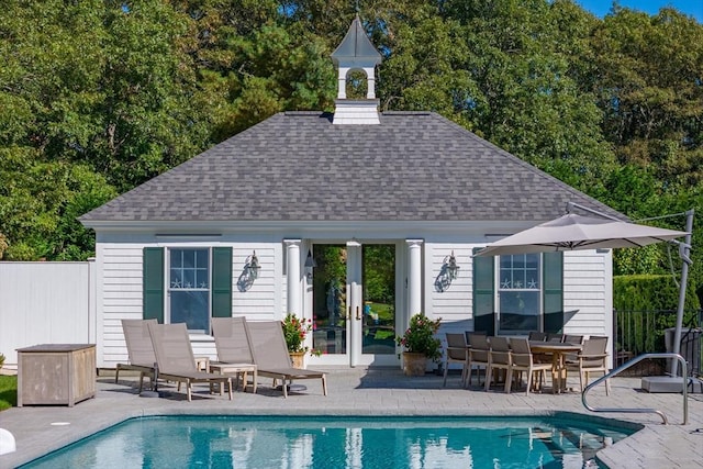 exterior space with an outbuilding, a fenced in pool, and a patio area