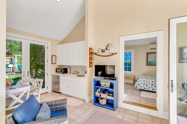 interior space with sink, light tile patterned floors, high vaulted ceiling, and french doors