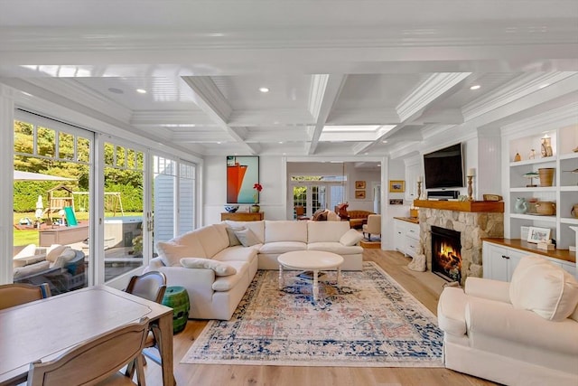 living room featuring beamed ceiling, a fireplace, coffered ceiling, and light hardwood / wood-style flooring