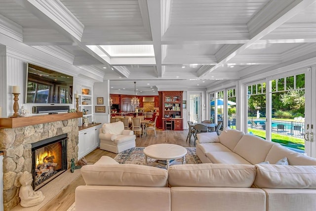 living room with coffered ceiling, beam ceiling, crown molding, light wood-type flooring, and a fireplace