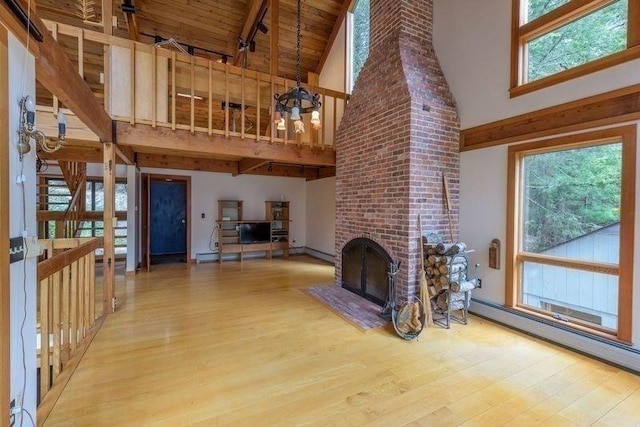 20 Lawton Rd, Leverett, MA 01054 - unfurnished living room with high vaulted ceiling, wood finished floors, baseboard heating, beamed ceiling, and healthy amount of natural light