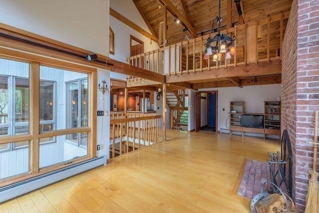 20 Lawton Rd, Leverett, MA 01054 - unfurnished living room featuring a baseboard heating unit, high vaulted ceiling, a chandelier, wood finished floors, and beamed ceiling