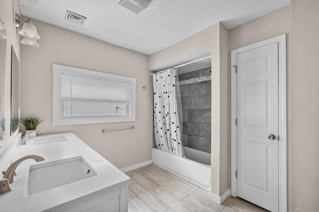 4002 Church St, Palmer, MA 01069 - full bath featuring double vanity, a textured ceiling, shower / bathtub combination with curtain, and wood finished floors