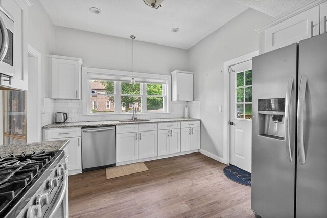 4002 Church St, Palmer, MA 01069 - kitchen featuring appliances with stainless steel finishes, backsplash, white cabinetry, and light stone counters