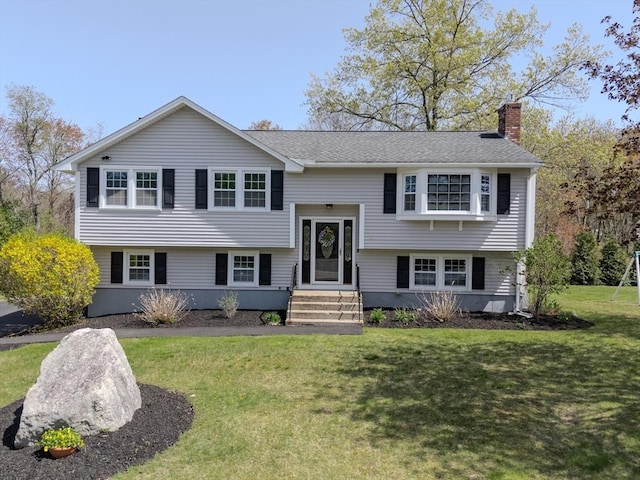 bi-level home with a front lawn and a chimney