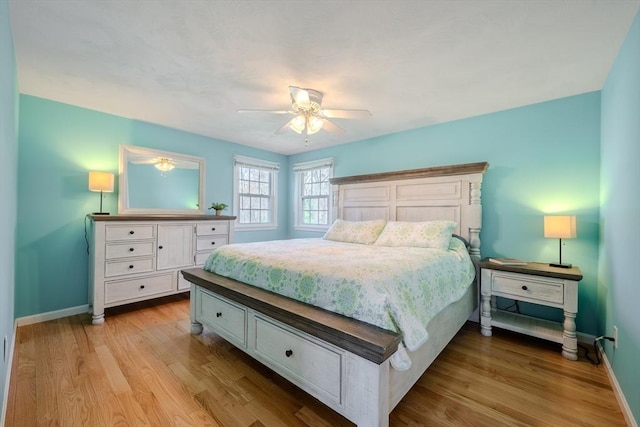 bedroom featuring baseboards, ceiling fan, and light wood-style flooring