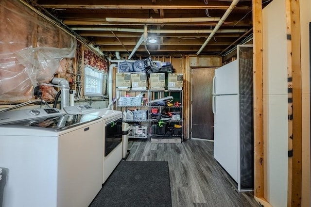 basement with freestanding refrigerator, dark wood-style flooring, and washer and clothes dryer