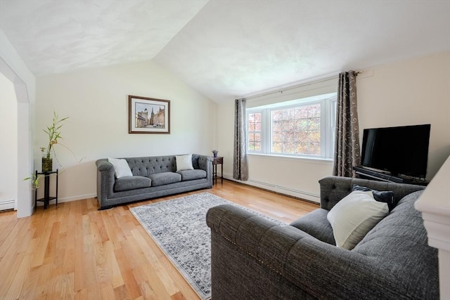 living area featuring baseboards, baseboard heating, vaulted ceiling, and light wood finished floors