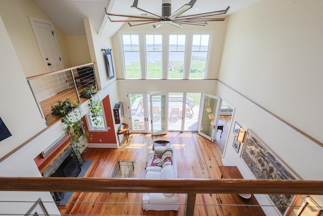 1794 Drift Unit E, Westport, MA 02790 - living area featuring a ceiling fan, wood finished floors, a towering ceiling, french doors, and a water view