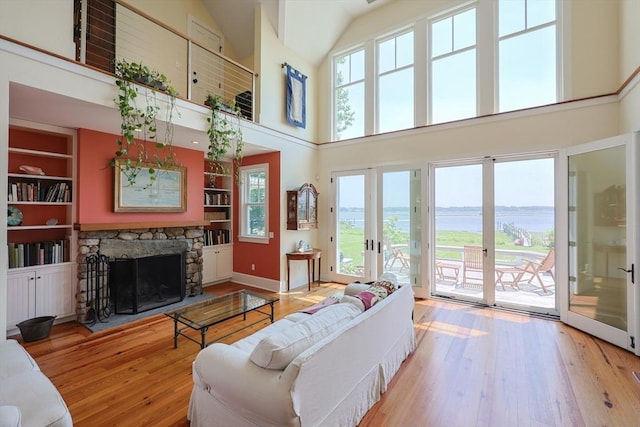 1794 Drift Unit E, Westport, MA 02790 - living area featuring a water view, a high ceiling, hardwood / wood-style flooring, a fireplace, and french doors