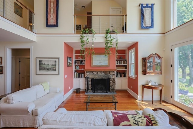 1794 Drift Unit E, Westport, MA 02790 - living room featuring a towering ceiling, wood finished floors, a stone fireplace, and built in shelves