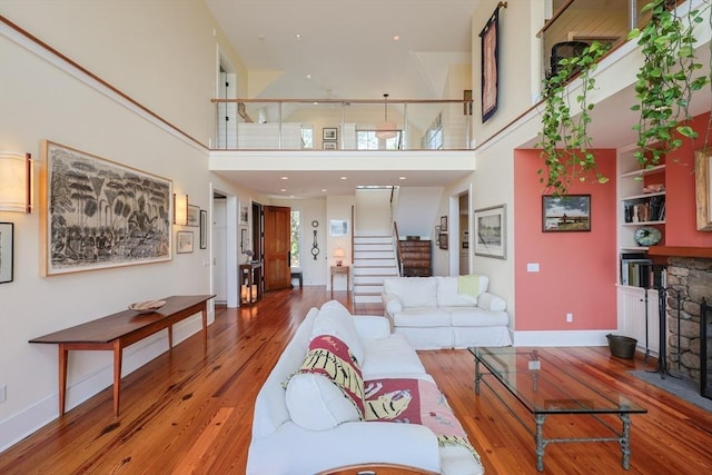 1794 Drift Unit E, Westport, MA 02790 - living room featuring hardwood / wood-style floors, stairs, a towering ceiling, and a fireplace