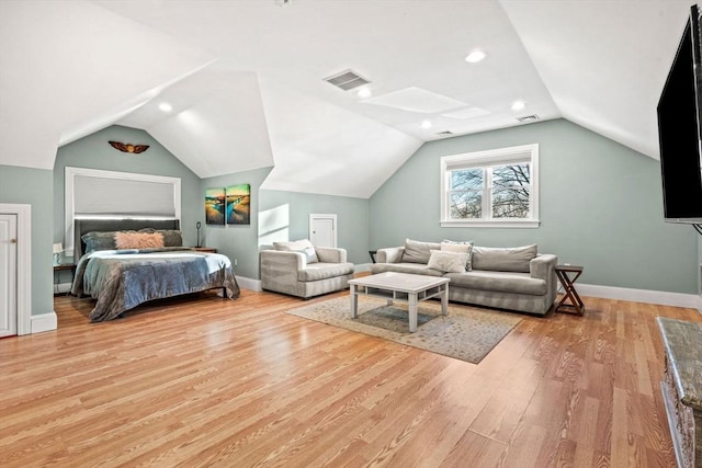 bedroom with vaulted ceiling, light wood finished floors, visible vents, and baseboards