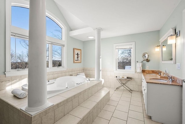 bathroom featuring tile patterned flooring, a healthy amount of sunlight, a garden tub, and ornate columns