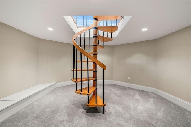 stairs featuring a skylight, carpet flooring, baseboards, and recessed lighting