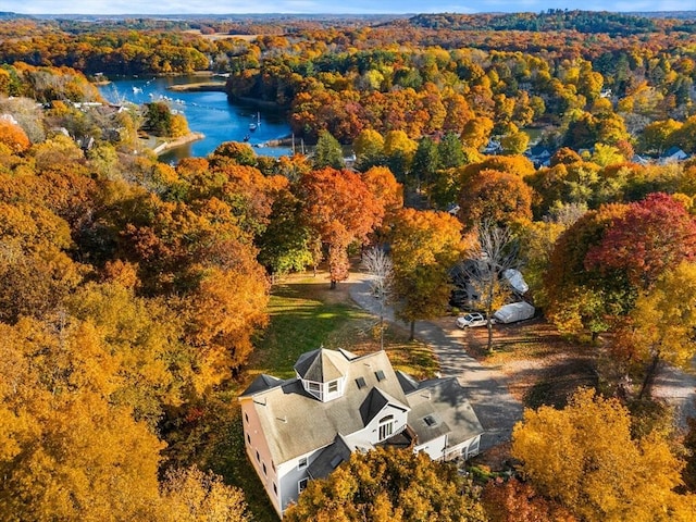 birds eye view of property featuring a water view and a wooded view