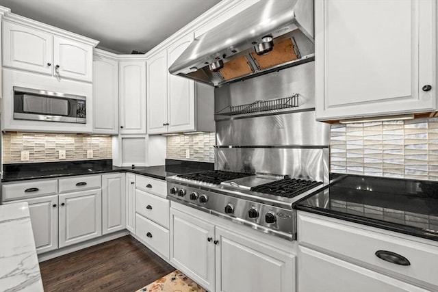 kitchen with appliances with stainless steel finishes, range hood, white cabinetry, and dark wood-type flooring