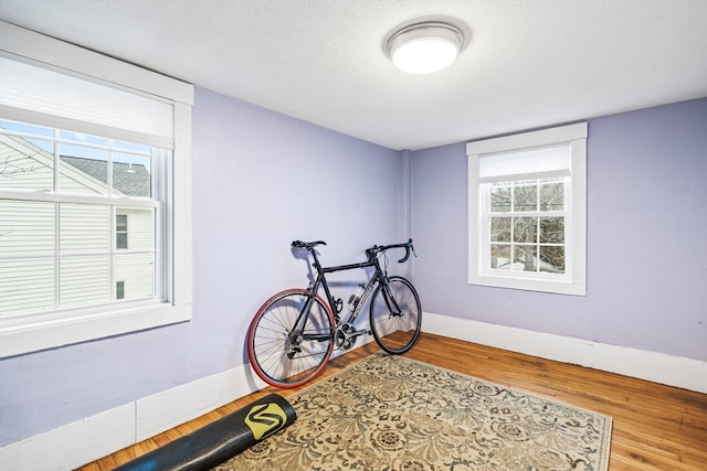 workout room with hardwood / wood-style flooring and a textured ceiling