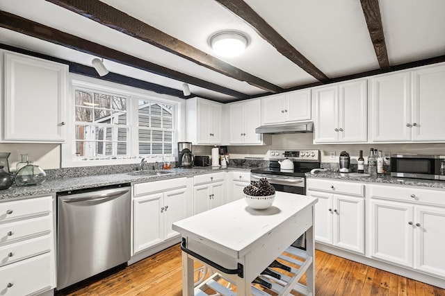 kitchen featuring light stone counters, stainless steel appliances, white cabinetry, beamed ceiling, and light hardwood / wood-style flooring