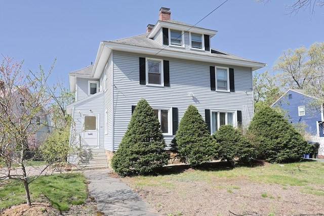 view of front facade with a chimney and entry steps