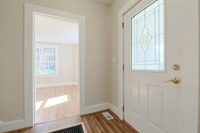 doorway with wood finished floors and baseboards