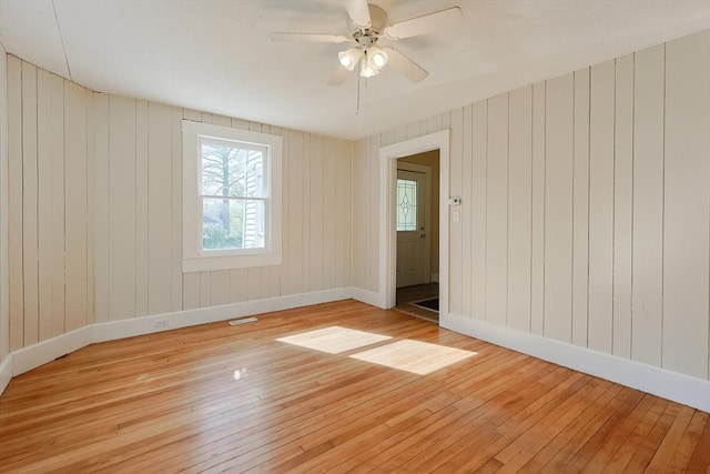 empty room with light wood-type flooring, baseboards, and ceiling fan