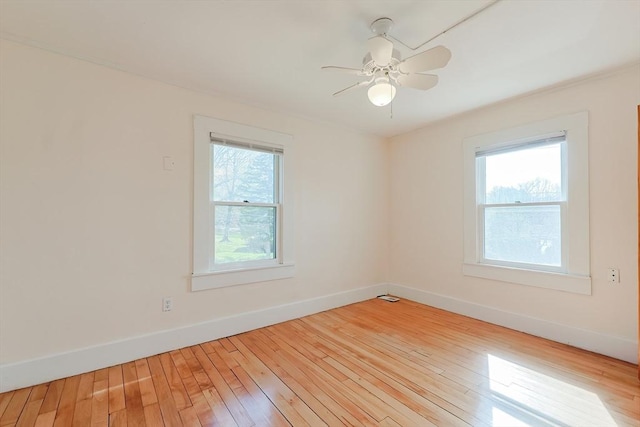 empty room featuring baseboards, wood-type flooring, and a ceiling fan