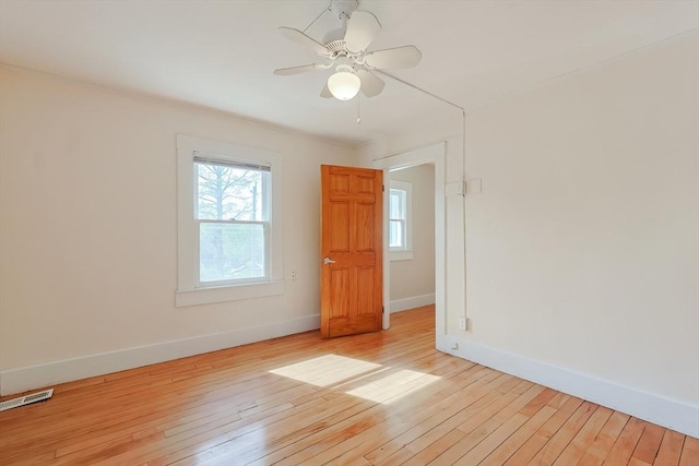 unfurnished room featuring baseboards, light wood finished floors, and ceiling fan
