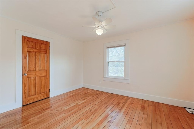 empty room featuring light wood-type flooring, baseboards, and a ceiling fan