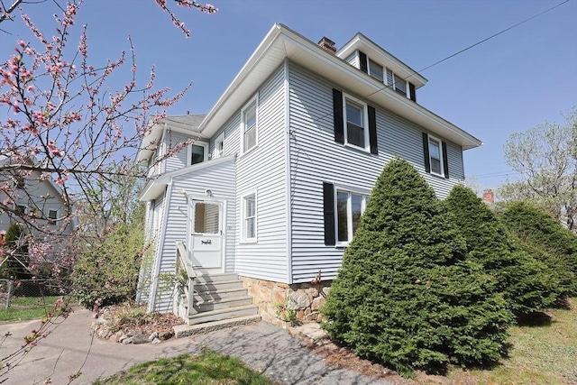 view of front of home featuring entry steps and fence