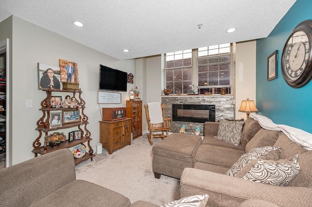 carpeted living area with recessed lighting, a textured ceiling, and a stone fireplace