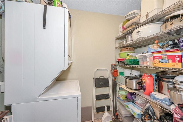 washroom featuring stacked washer and dryer and laundry area