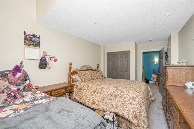 bedroom featuring a textured ceiling, carpet flooring, and a closet