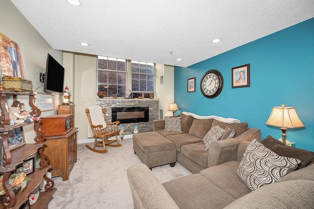 carpeted living area featuring a textured ceiling, recessed lighting, a stone fireplace, and baseboards