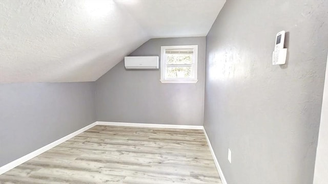55 Mendon St, Worcester, MA 01604 - additional living space with an AC wall unit, lofted ceiling, wood finished floors, baseboards, and a textured ceiling