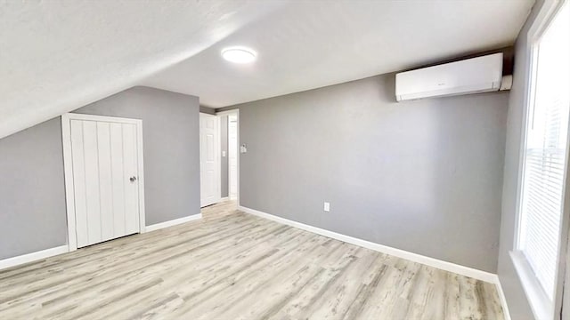 55 Mendon St, Worcester, MA 01604 - additional living space featuring a wall mounted AC, wood finished floors, baseboards, lofted ceiling, and healthy amount of natural light