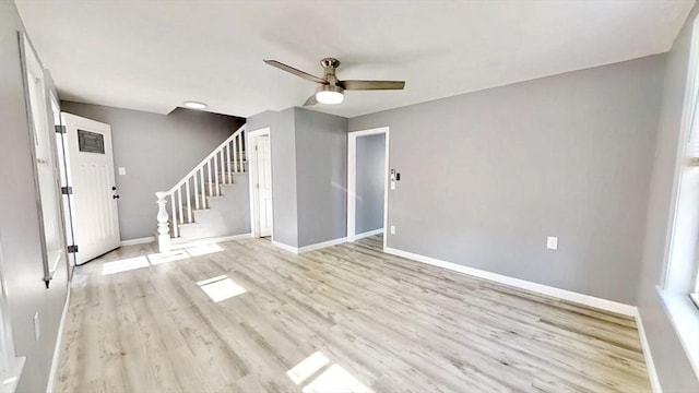 55 Mendon St, Worcester, MA 01604 - unfurnished living room with baseboards, a ceiling fan, light wood-style flooring, and stairs