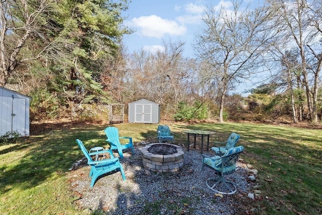 view of grassy yard with a storage shed, an outdoor fire pit, and an outbuilding