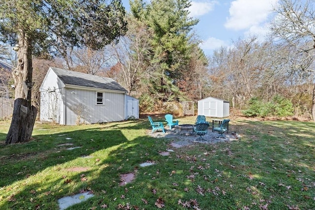 view of green lawn featuring a storage shed, a fire pit, and an outdoor structure