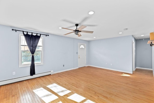 unfurnished living room with attic access, a baseboard radiator, ceiling fan, light wood-style flooring, and baseboards